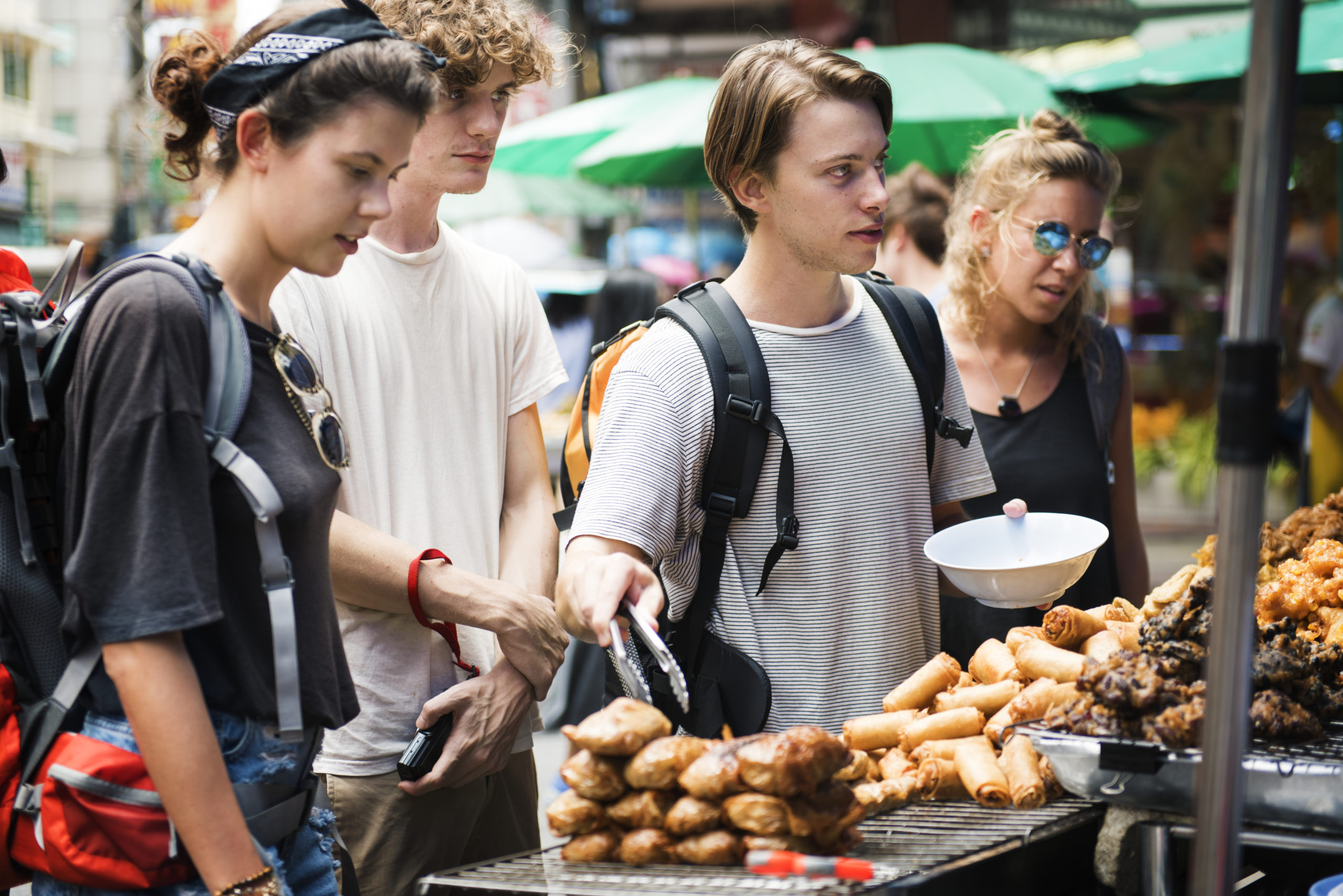 group of tourists buying thai food at food stall